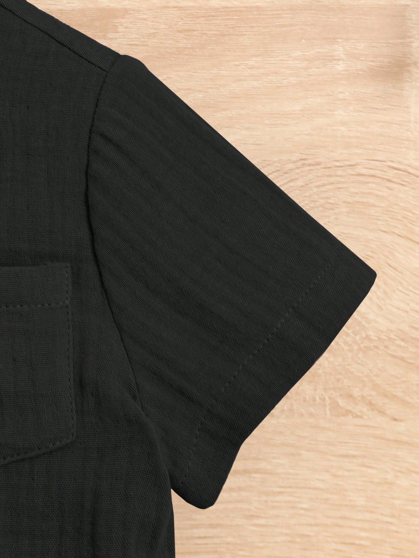 Prenda negra conjunto de camisa y shorts para bebé detalle de manga corta y acabado