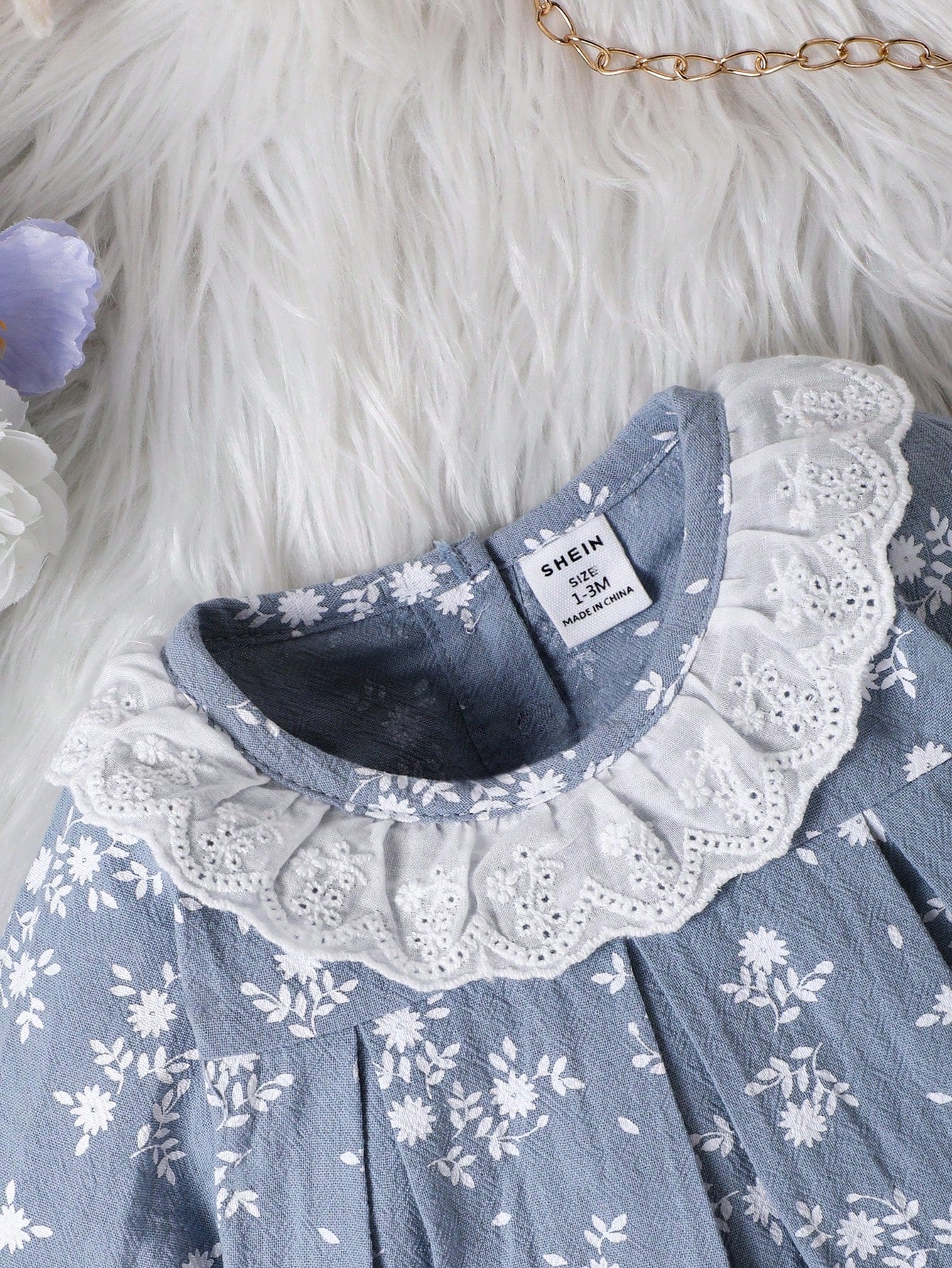 Prenda azul vestido para bebe con detalle de cuello de encaje y estampado floral