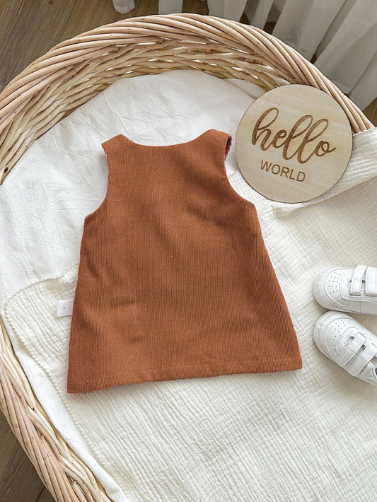 Prenda café vestido peto para bebe con textura de pana vista trasera