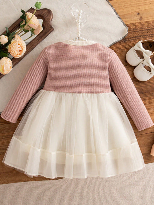Vestido rosa y marfil para bebé con mangas largas y falda de tul, vista trasera.