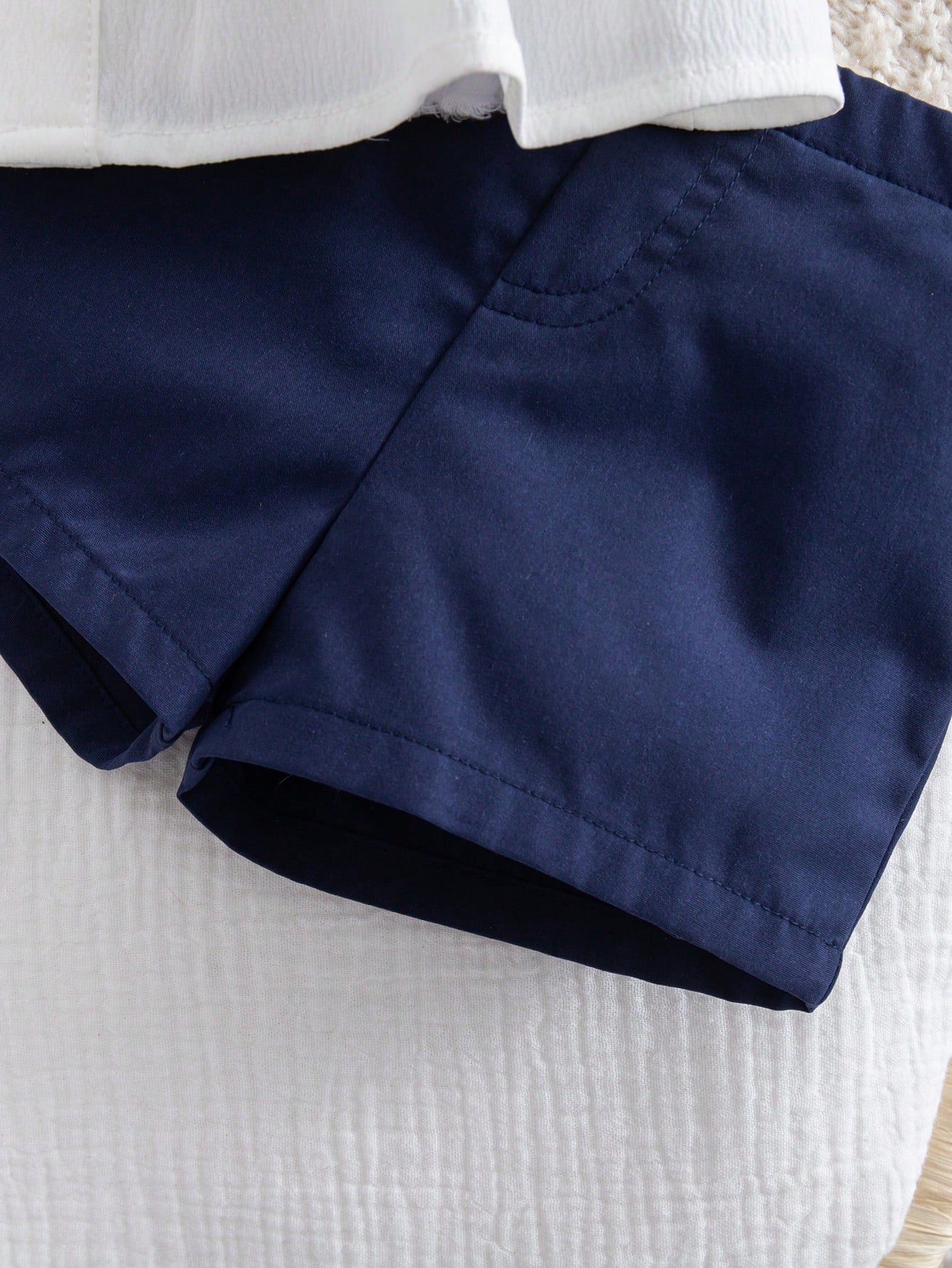 Prenda azul marino pantalón corto para bebe con detalle de costuras y acabado