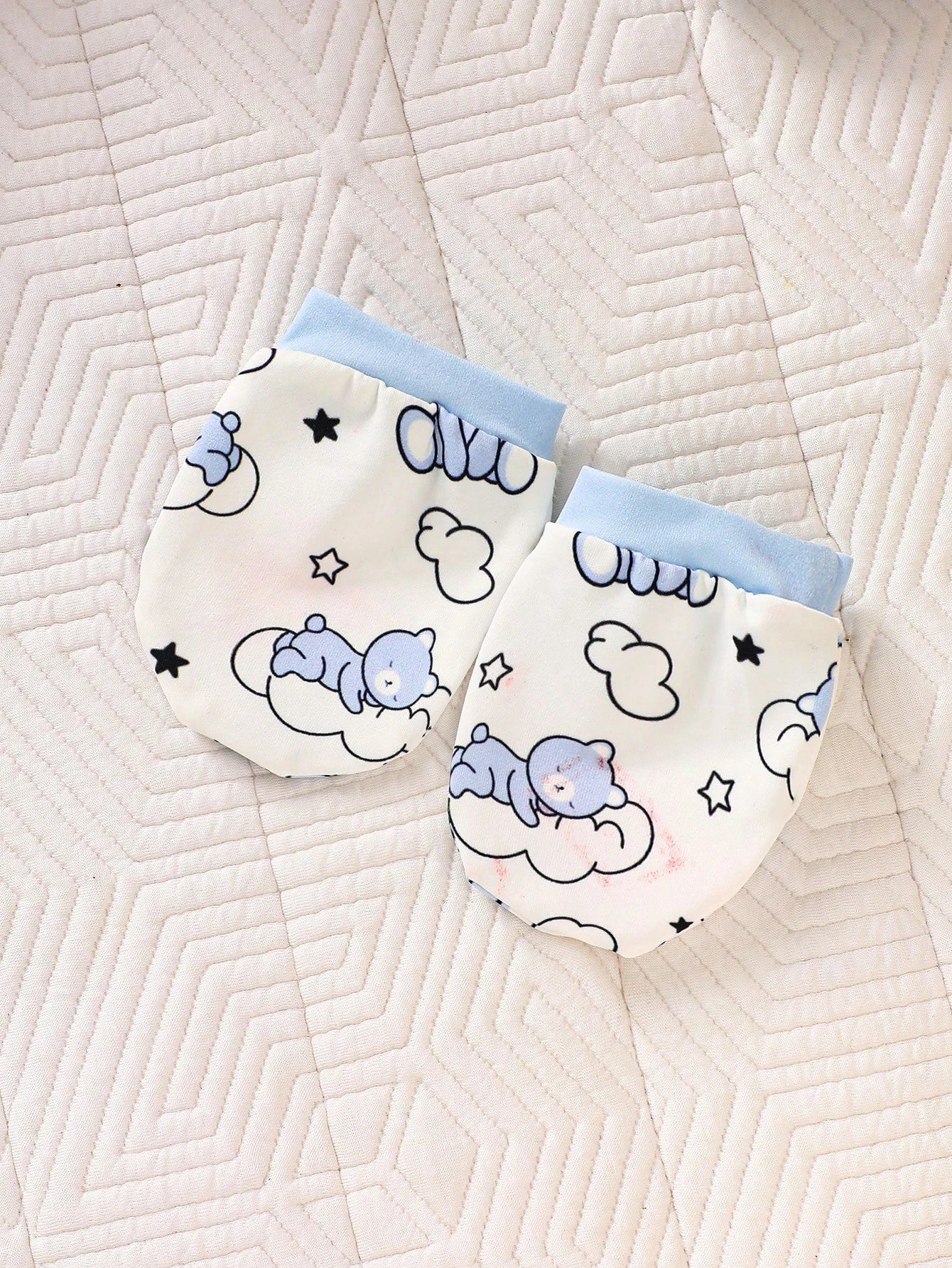 Prenda celeste manoplas para bebe con estampado de oso y nubes detalle de acabado
