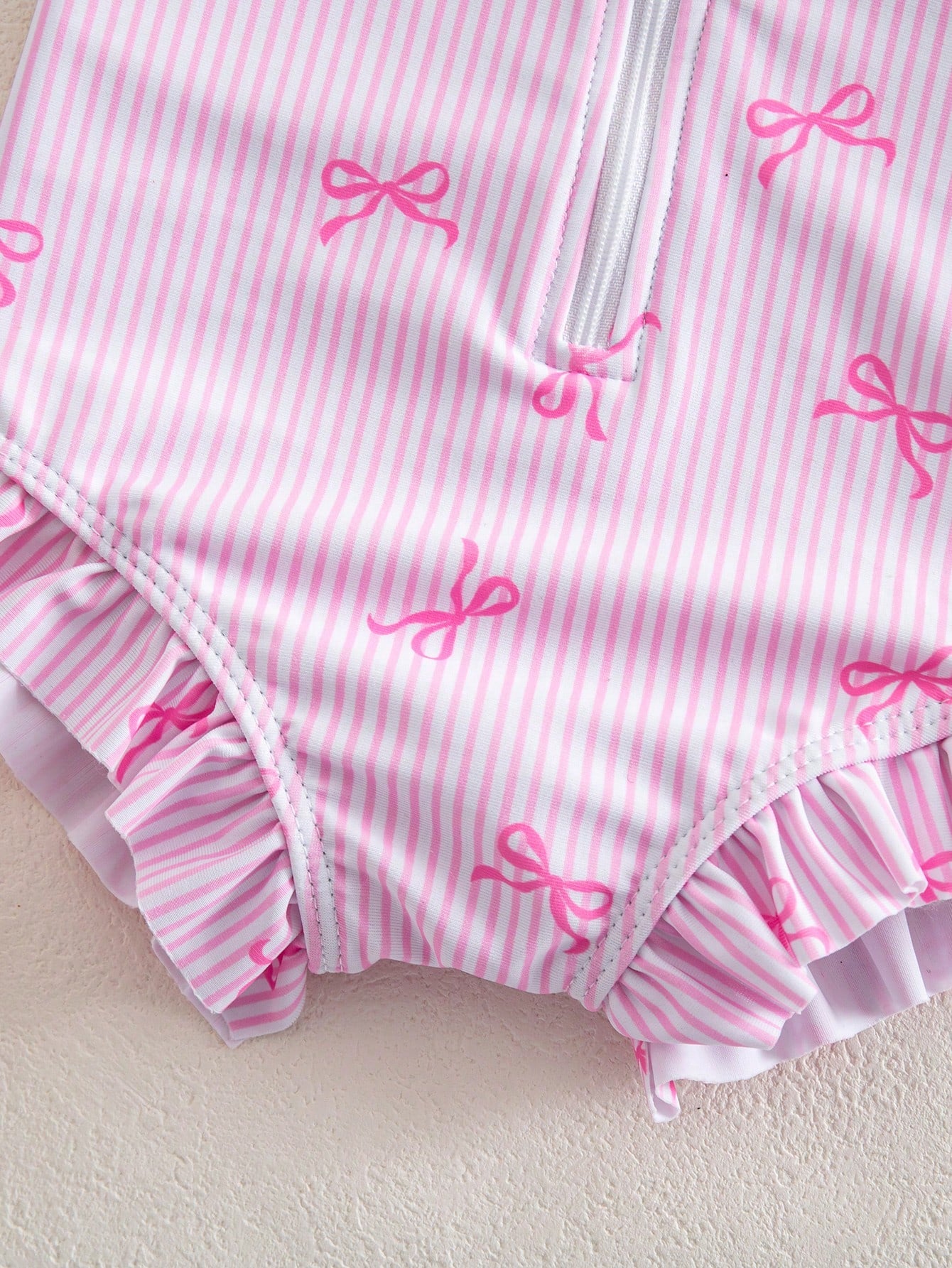 Prenda rosa traje de baño para bebe con detalle de volantes en el bajo