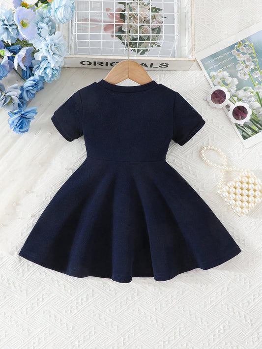 Prenda azul marino vestido para bebe con lazo blanco vista trasera
