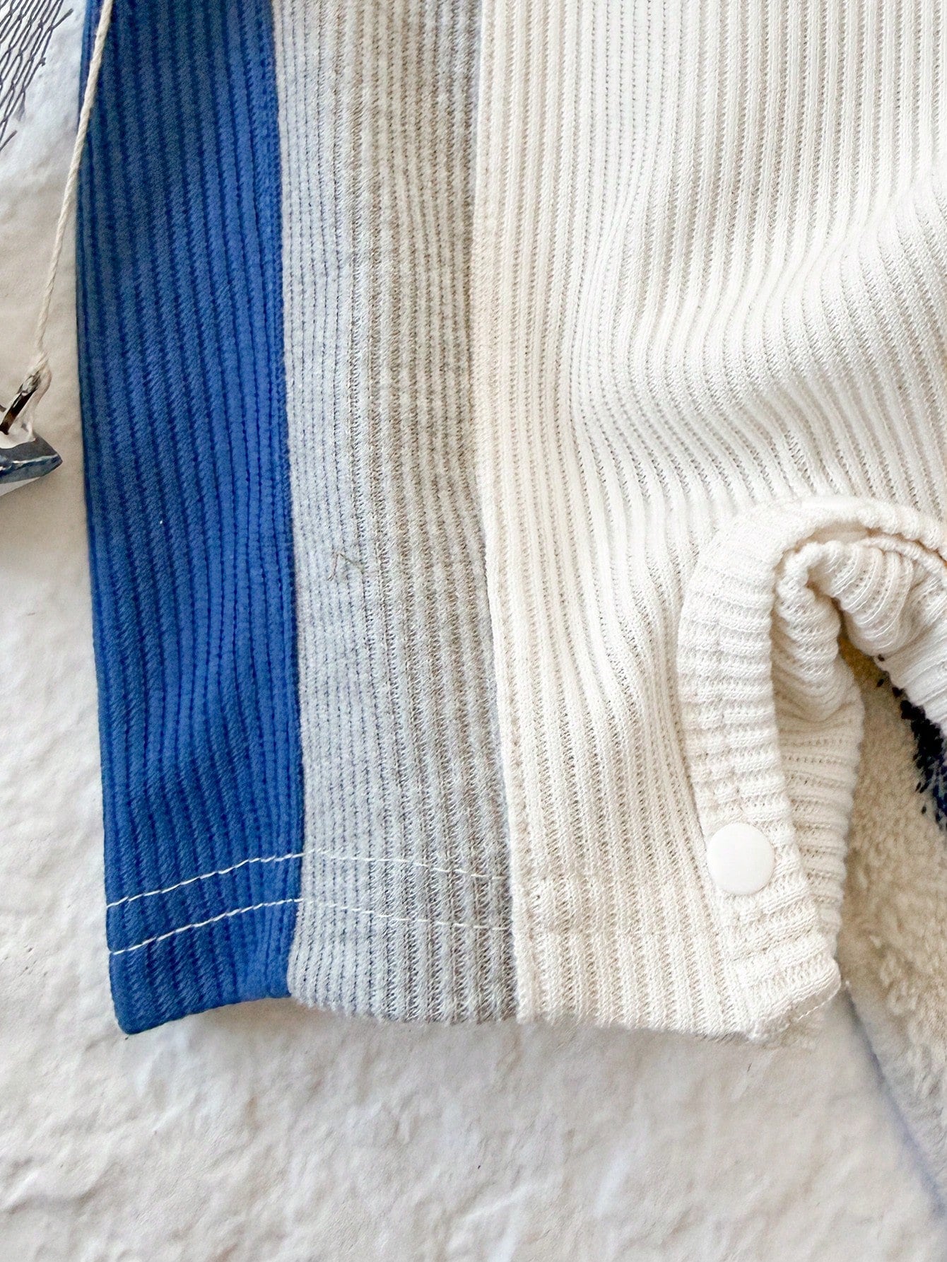 Prenda blanca pelele para bebe detalle de tejido acanalado y broches inferiores