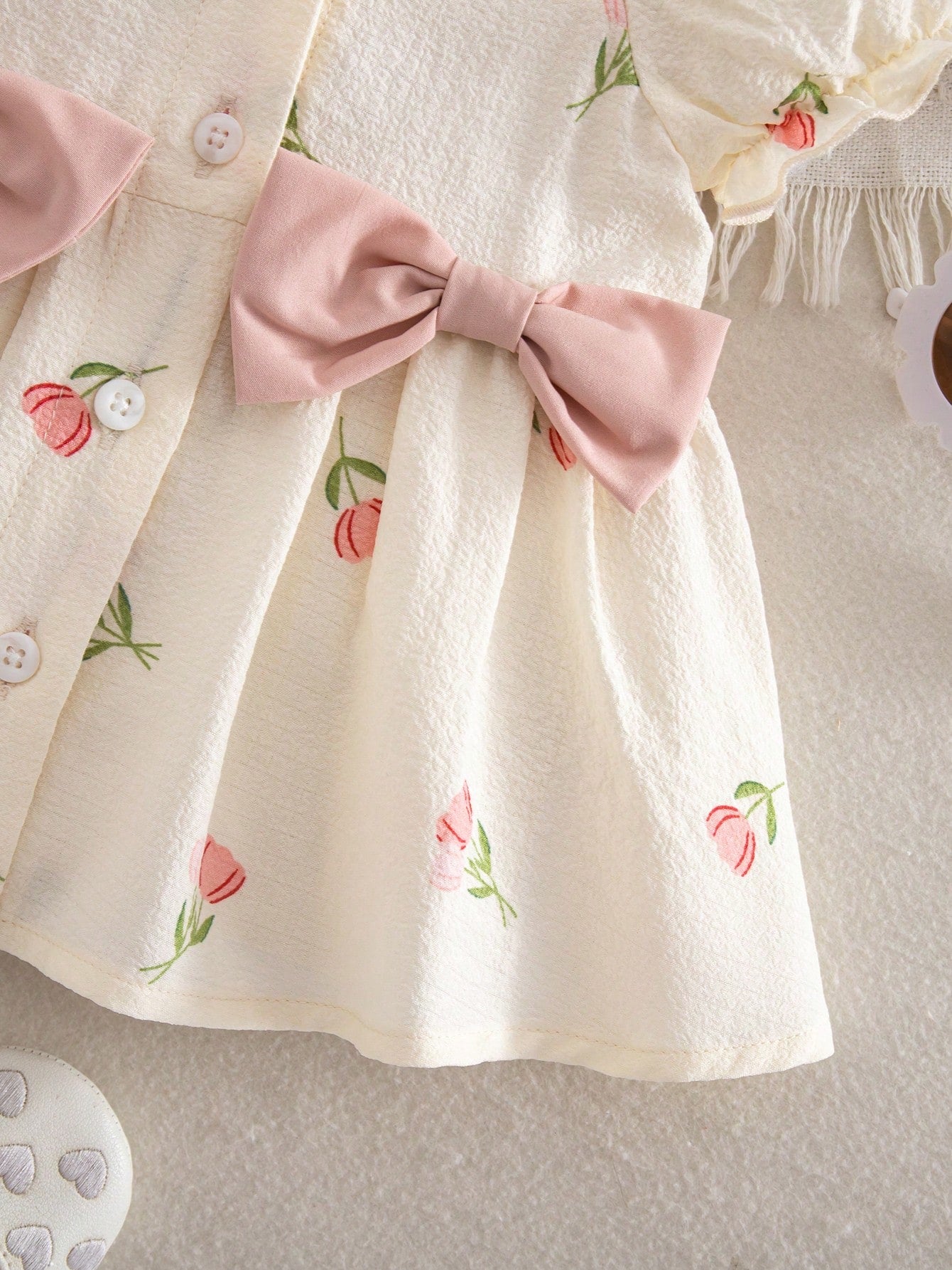 Prenda crema vestido para bebe detalle de falda floral y acabado