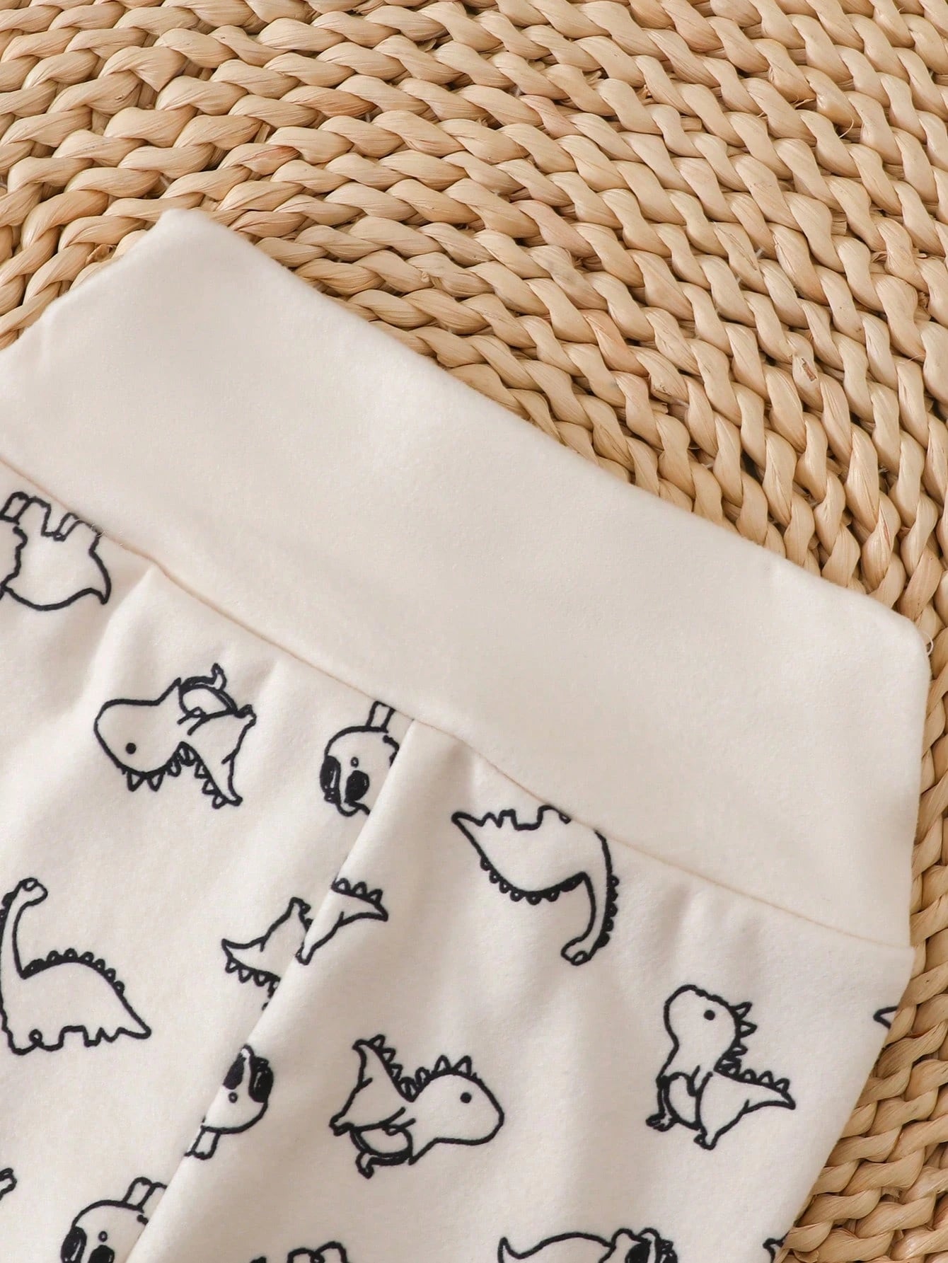 Prenda crema conjunto para bebe con detalle de cintura y estampado de dinosaurios