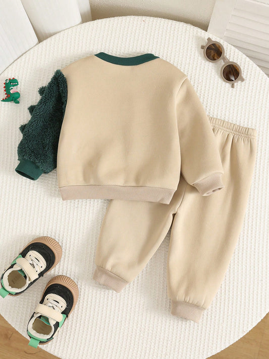 Conjunto beige con dinosaurio verde para bebé, vista trasera de sudadera y pantalón.