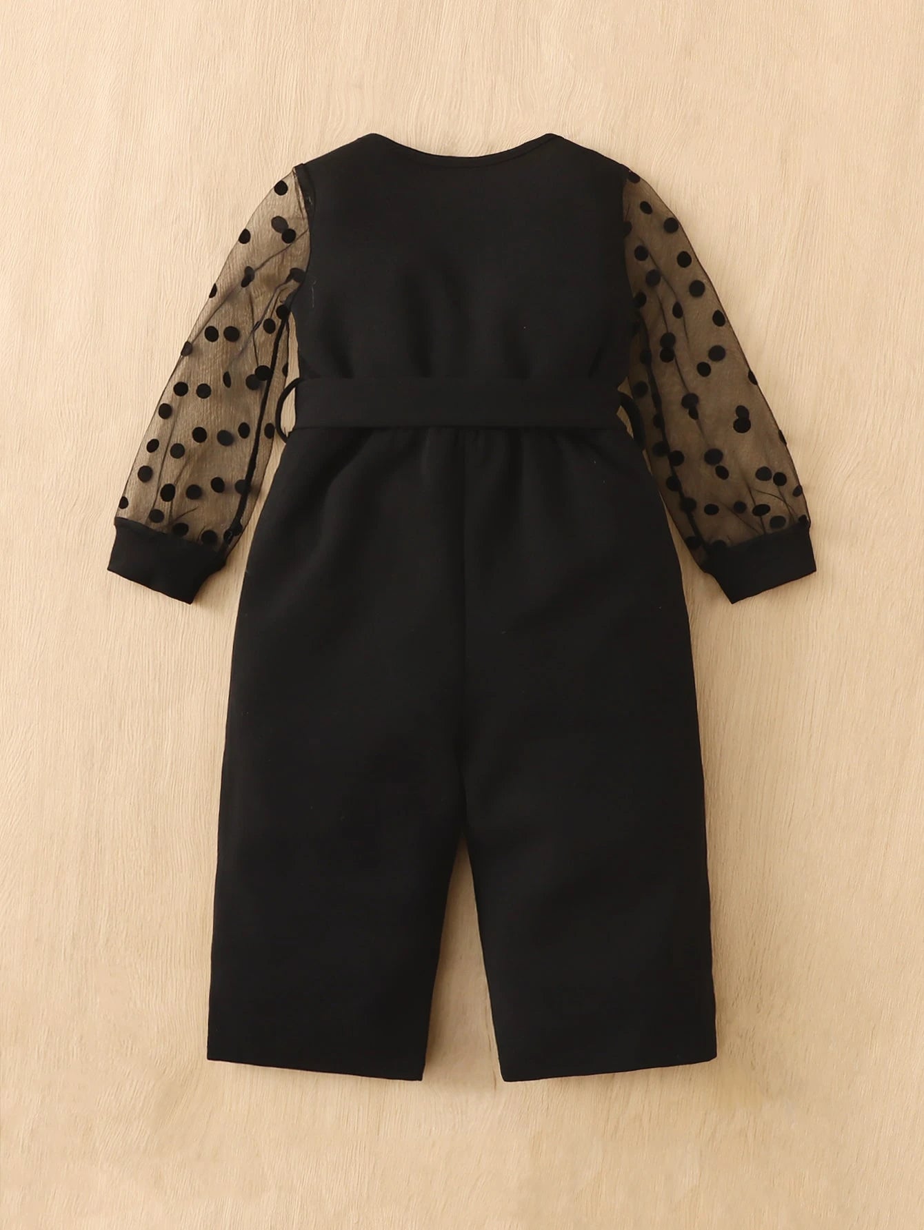 Prenda negra enterizo para bebe con malla de lunares vista trasera