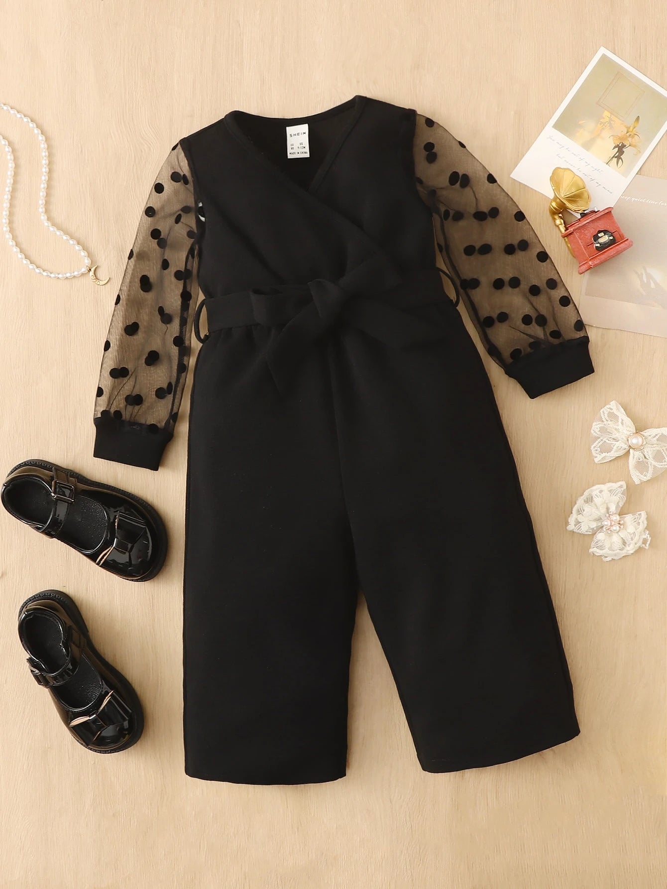 Prenda negra enterizo para bebe con malla de lunares vista frontal