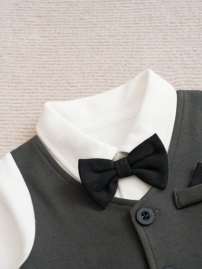 Prenda gris mameluco para bebe vista frontal con chaleco, botones y moño desmontable