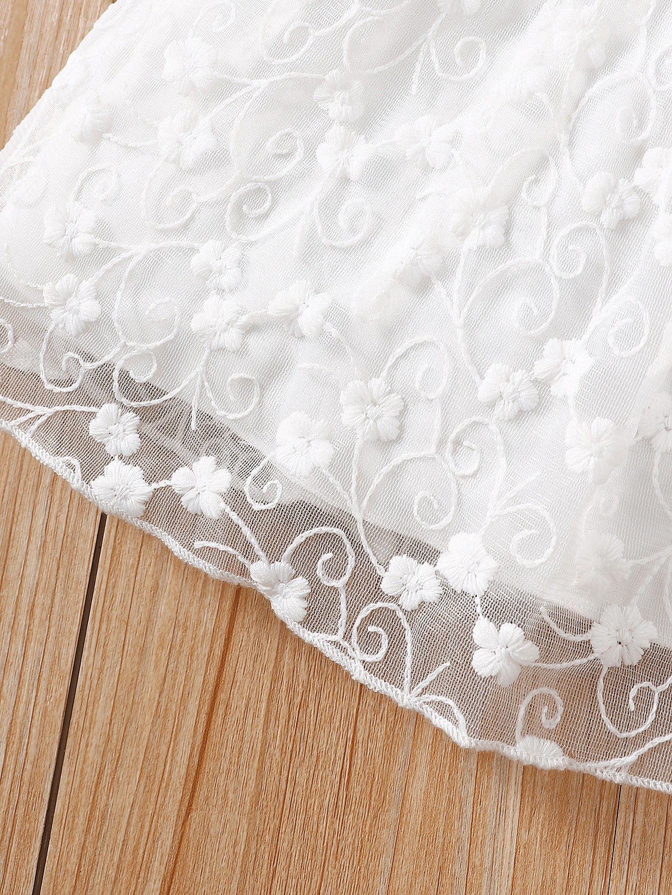 Vestido blanco bordado con volantes y malla elegante