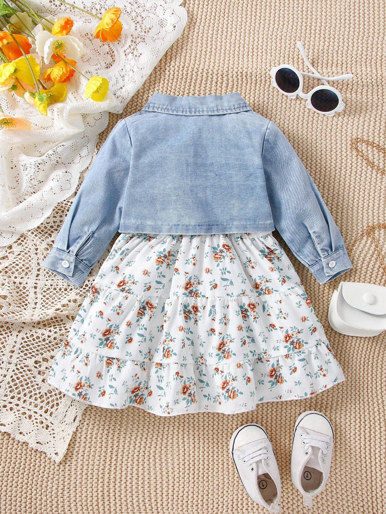 Prenda azul y blanca conjunto de vestido floral y chaqueta de mezclilla para bebe vista frontal