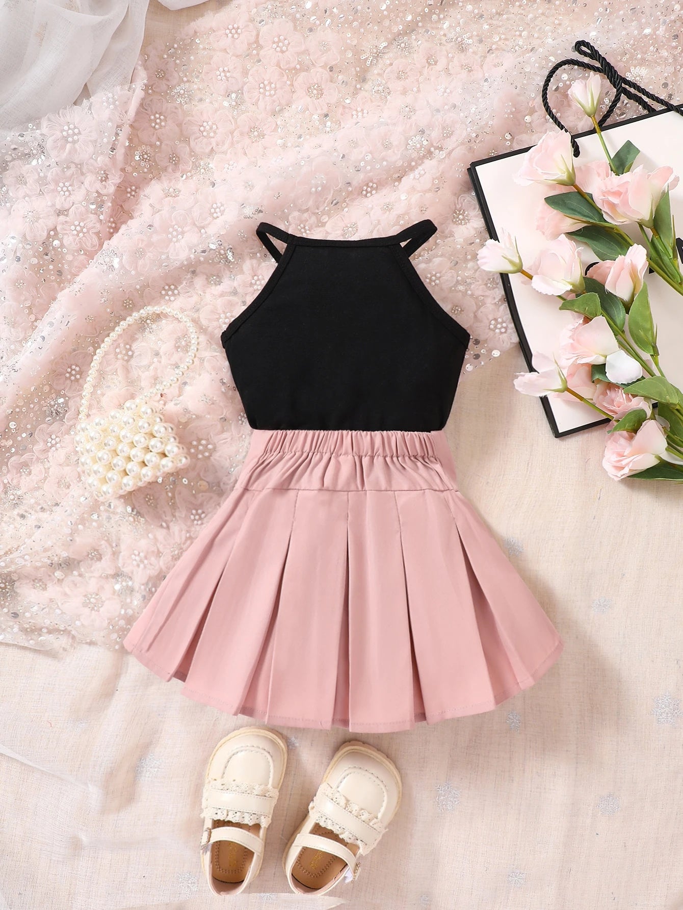 Prenda negro y rosa conjunto para bebe con falda plisada vista trasera

