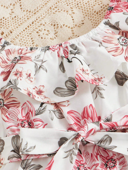 Prenda blanca enterizo para bebe con detalle de volantes y cinturón
