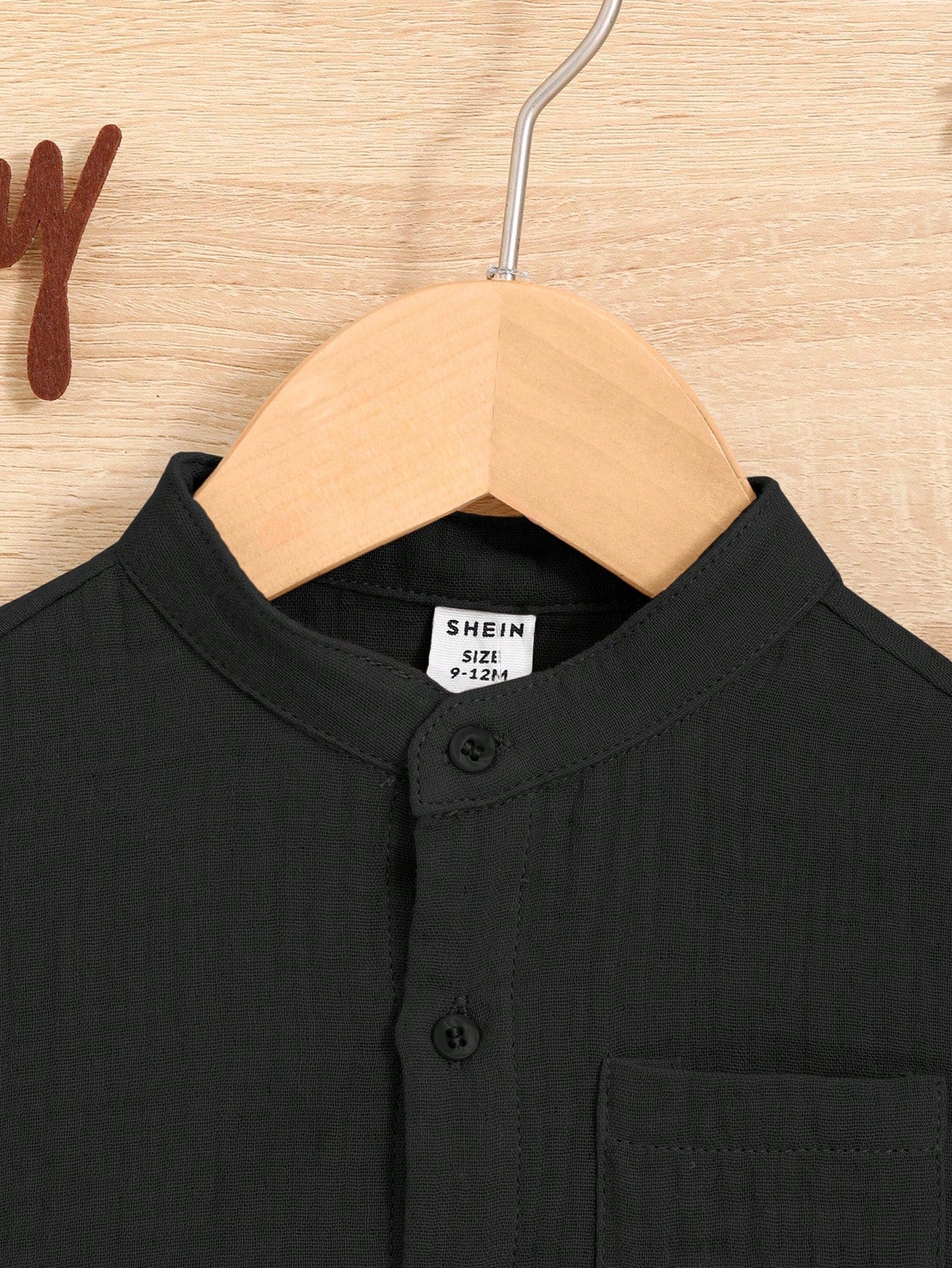 Prenda negra conjunto de camisa y shorts para bebé detalle de cuello mao y botones