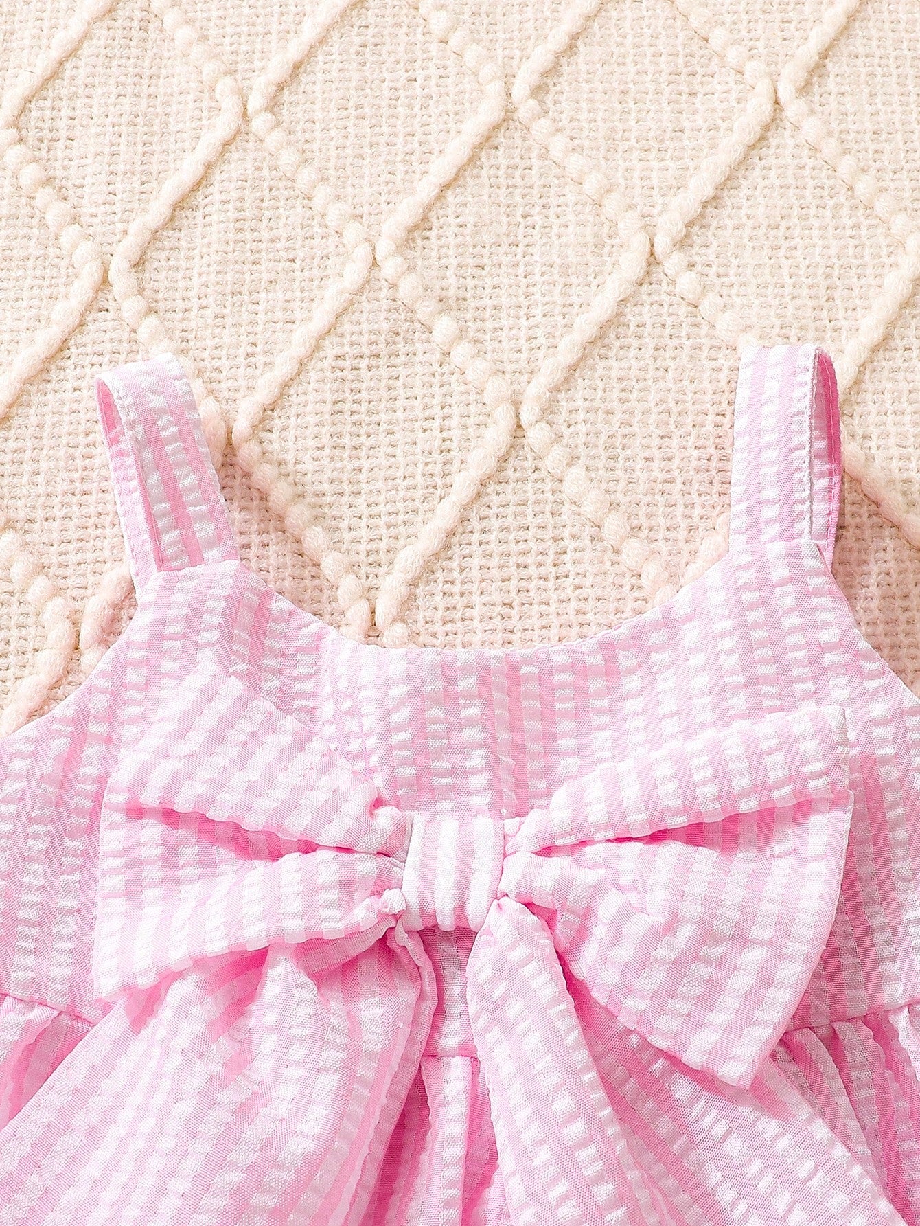 Prenda rosa vestido a rayas para bebe con detalle de tirantes y lazo frontal