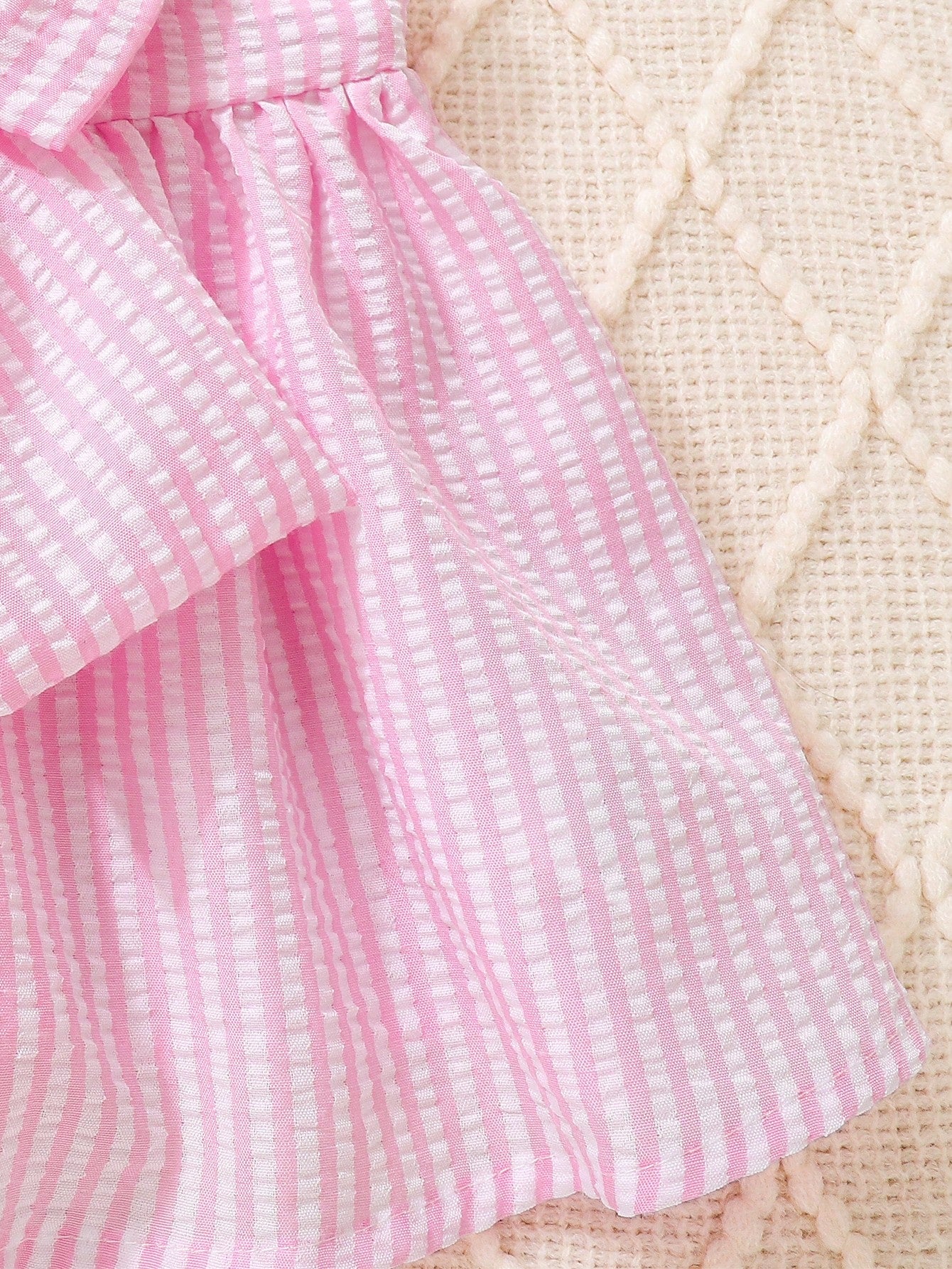 Prenda rosa vestido a rayas para bebe con detalle de textura y falda amplia