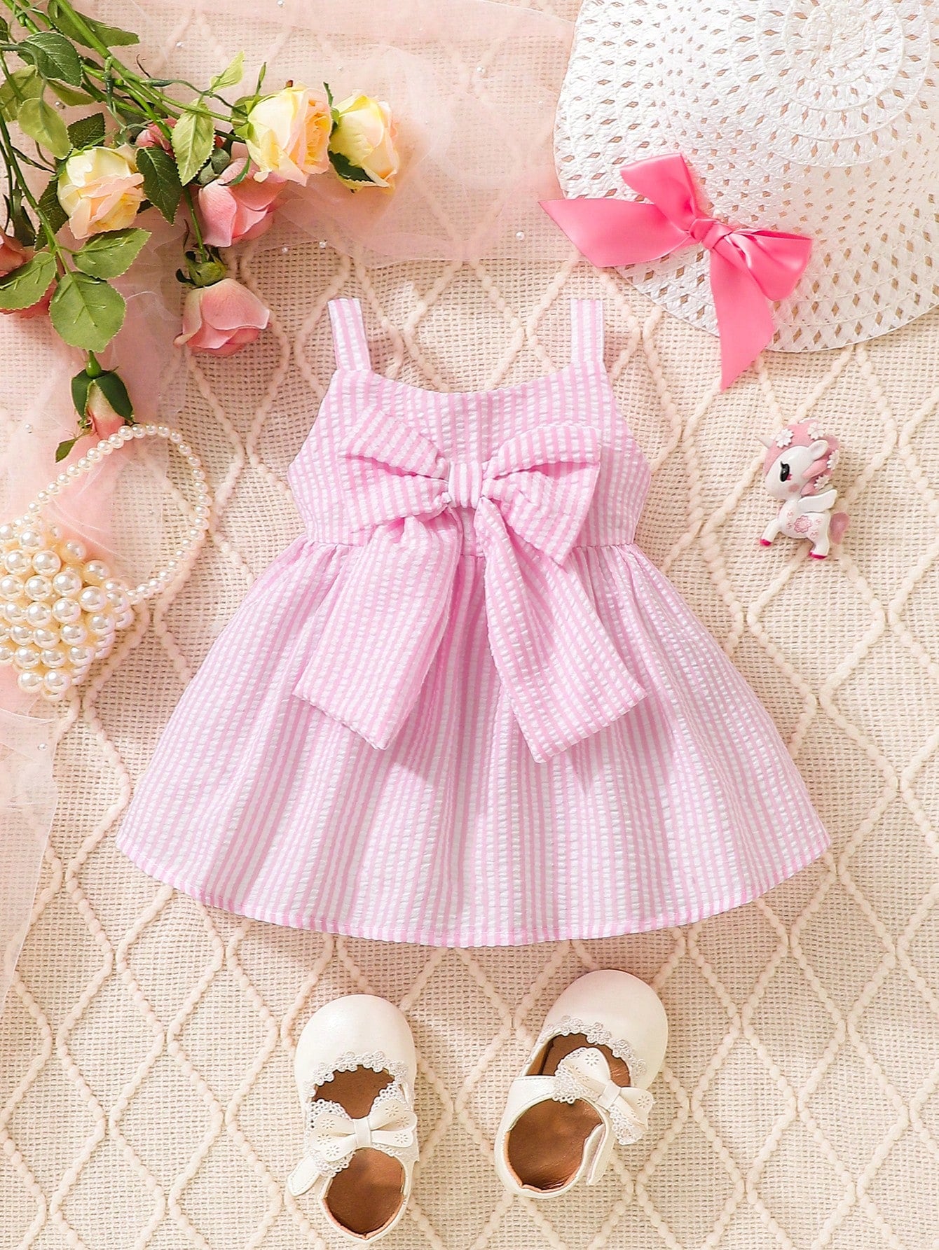 Prenda rosa vestido a rayas para bebe con lazo grande vista frontal