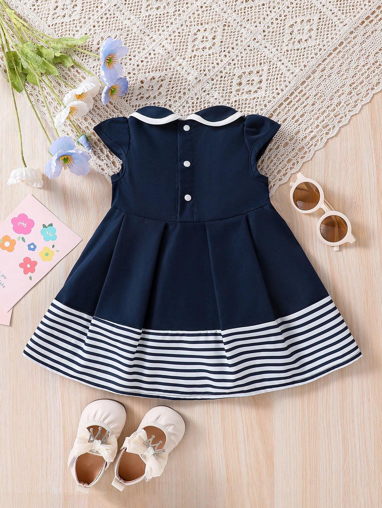Prenda azul marino vestido para bebe con franjas blancas vista trasera