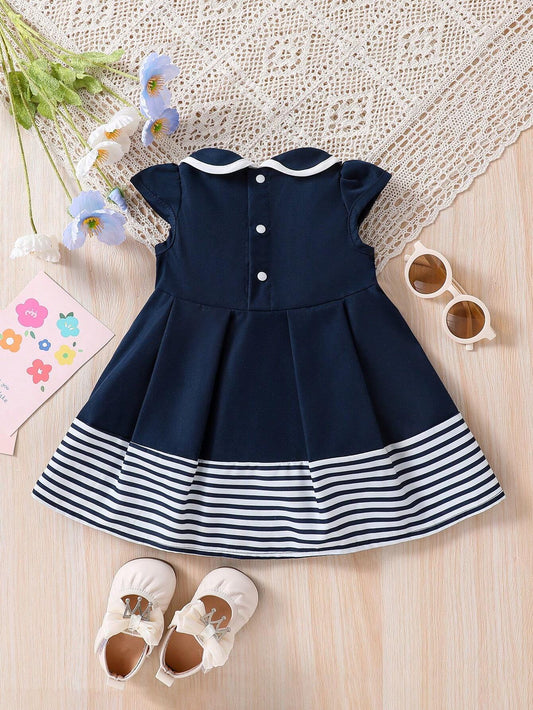 Prenda azul marino vestido para bebe con franjas blancas vista trasera