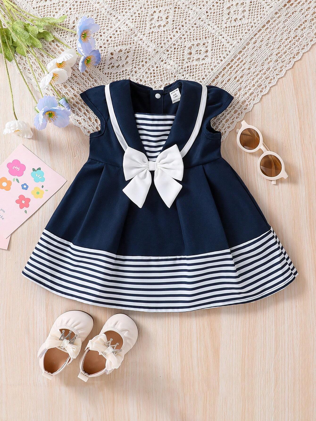 Prenda azul marino vestido para bebe con cuello marinero y lazo vista frontal