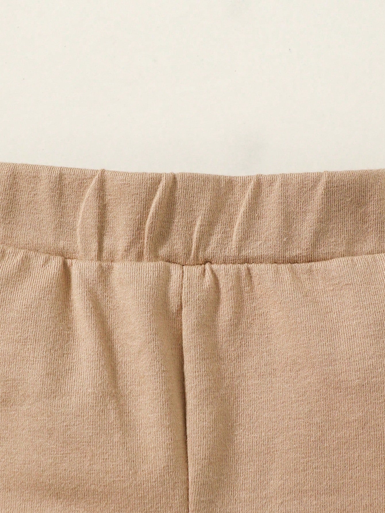 Prenda beige conjunto de tres piezas para bebe vista frontal con body de animales