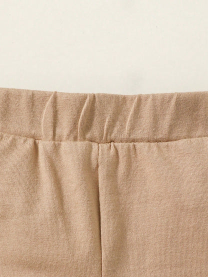Prenda beige conjunto de tres piezas para bebe vista frontal con body de animales