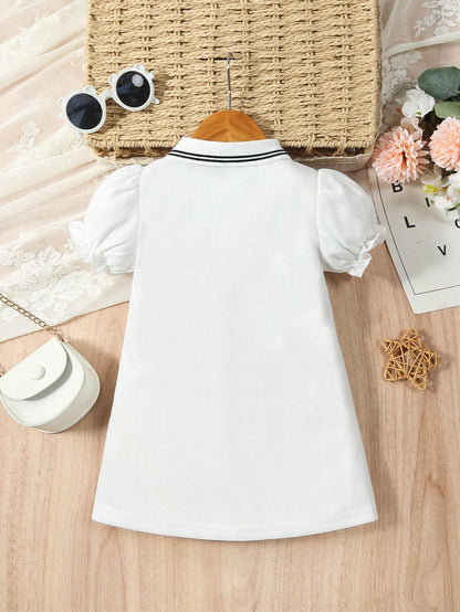 Prenda blanca vestido polo para bebe, vista posterior con cuello de líneas negras