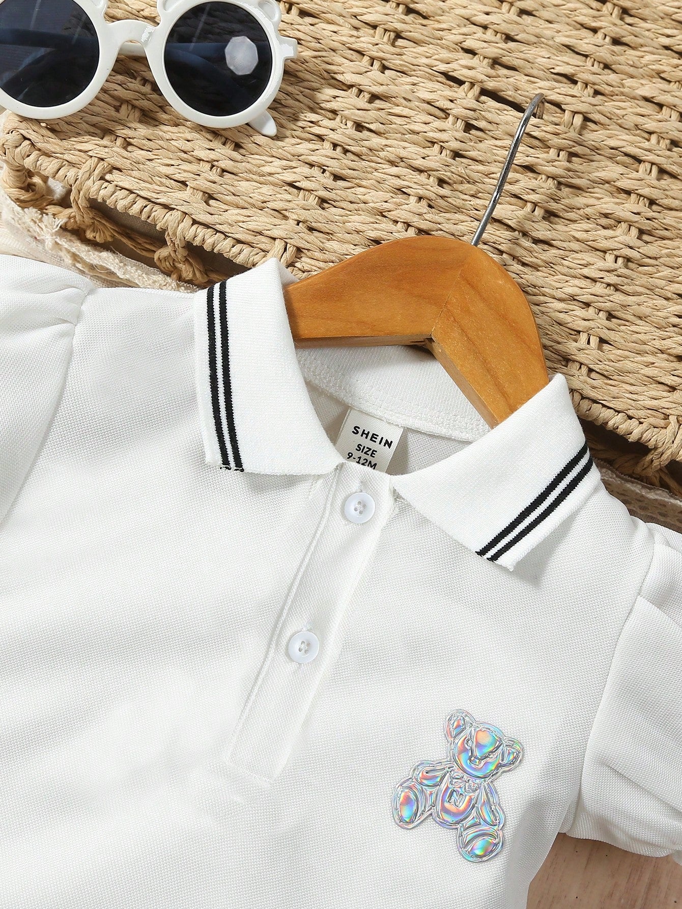Prenda blanca vestido polo para bebe, detalle del cuello y parche de oso tornasol