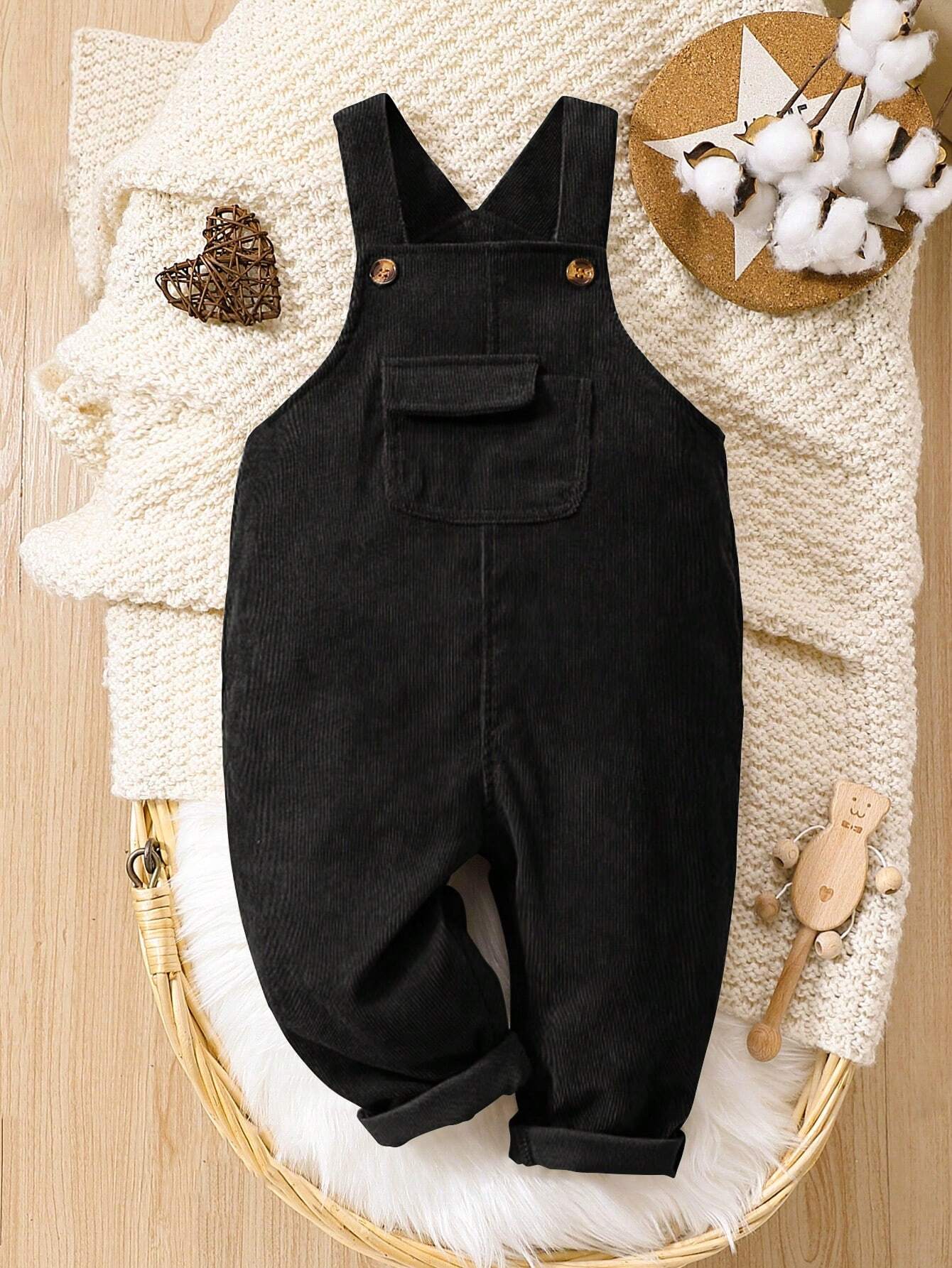 Prenda negro overol para bebe vista frontal con bolsillo y botones