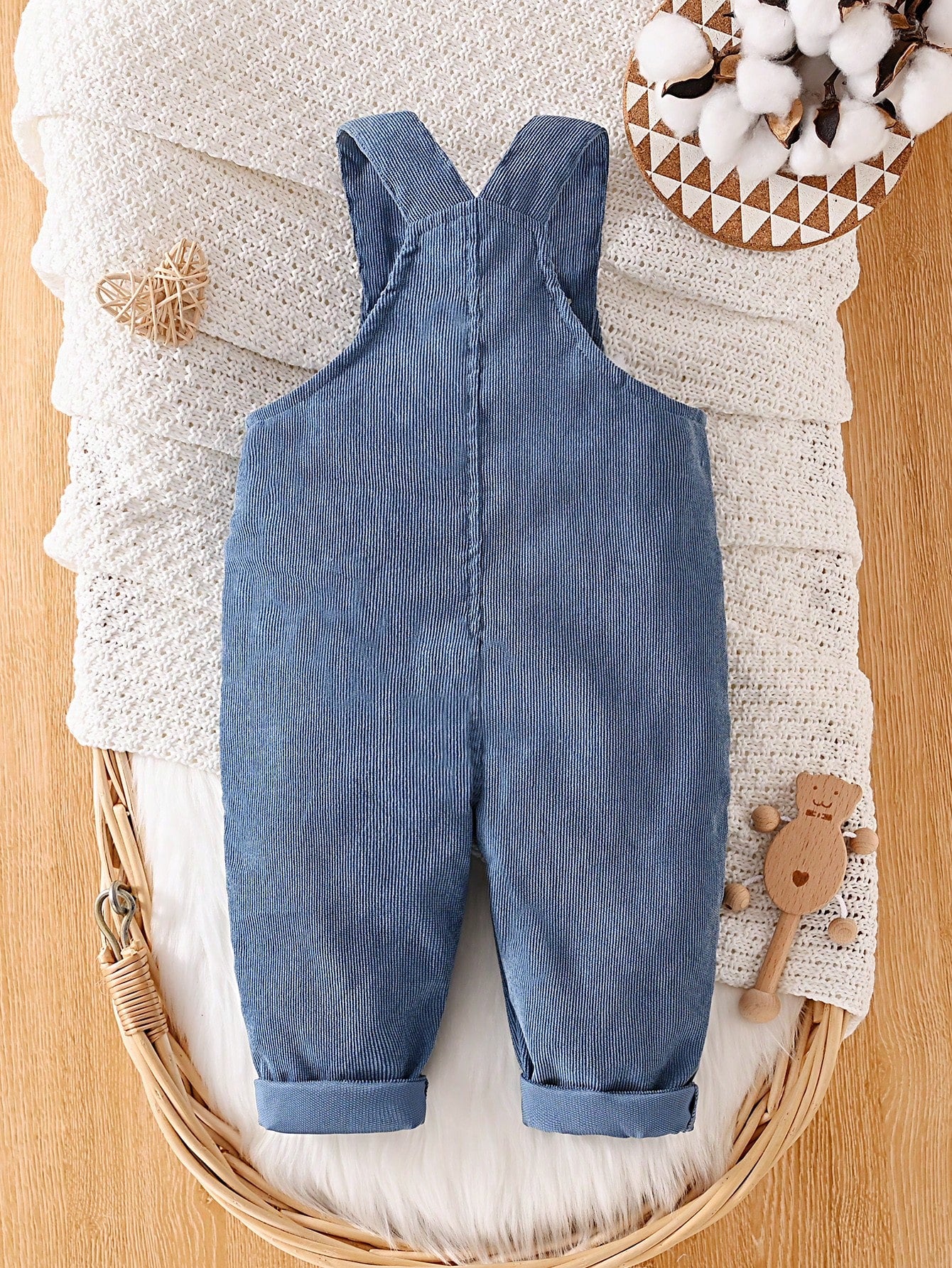 Prenda azul overol para bebe vista trasera con tirantes cruzados
