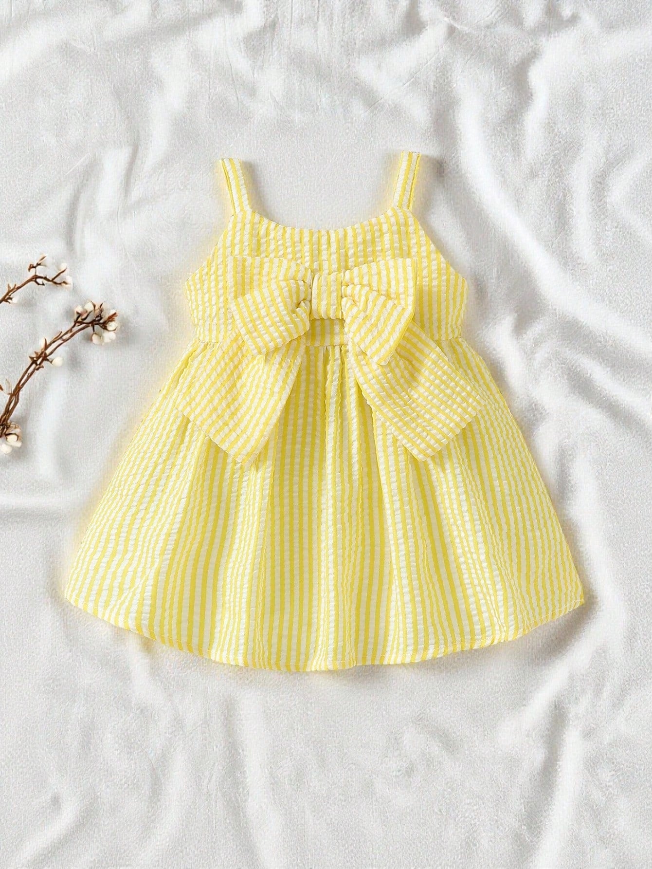 Prenda amarilla vestido a rayas para bebe con lazo grande vista frontal