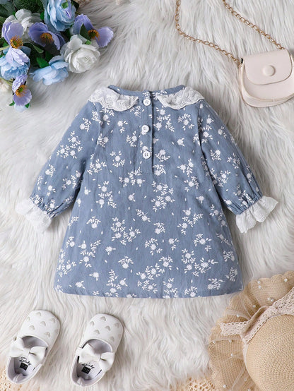 Prenda azul vestido para bebe con estampado floral y botones vista posterior