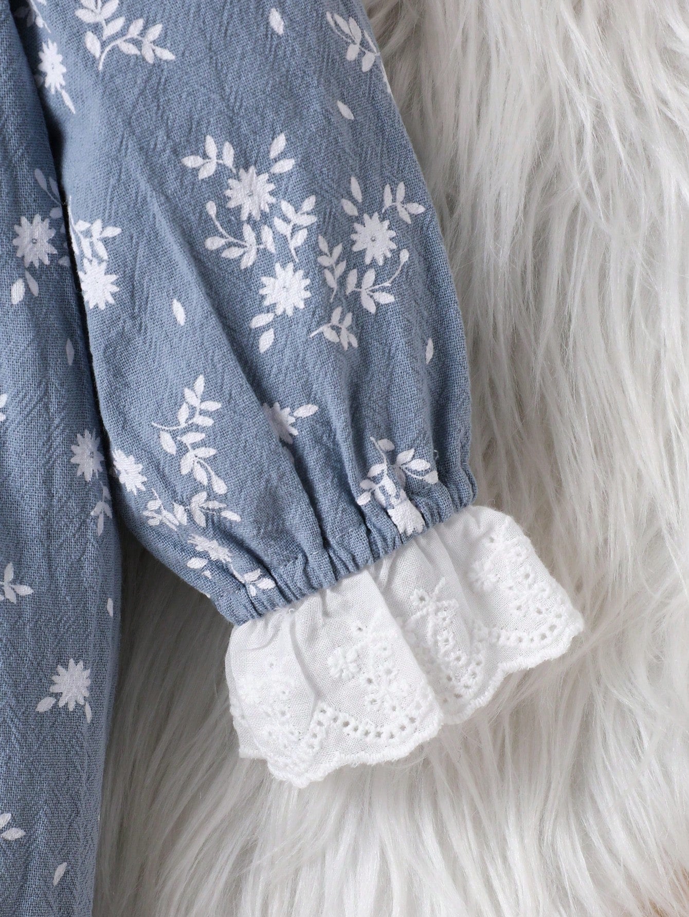 Prenda azul vestido para bebe con detalle de puño con volante y bordado
