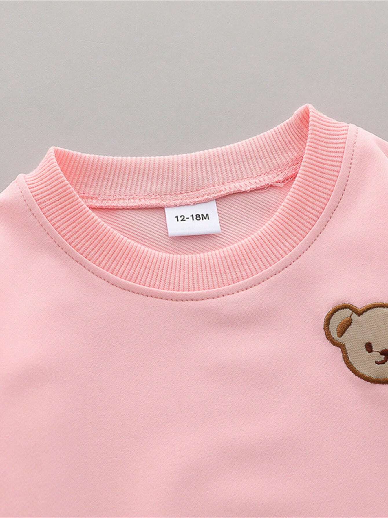 Prenda rosa sudadera para bebe con detalle de cuello y parche de oso
