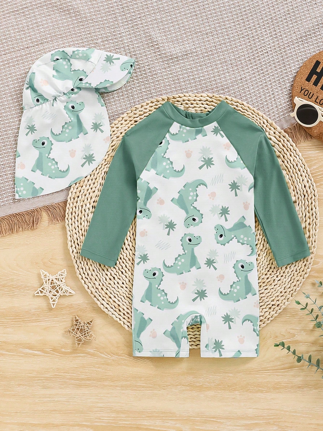 Prenda verde menta traje de baño para bebe con dinosaurios y gorro vista trasera