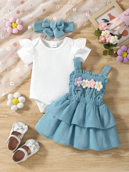 Prenda azul conjunto para bebe con flores bordadas y body blanco vista frontal
