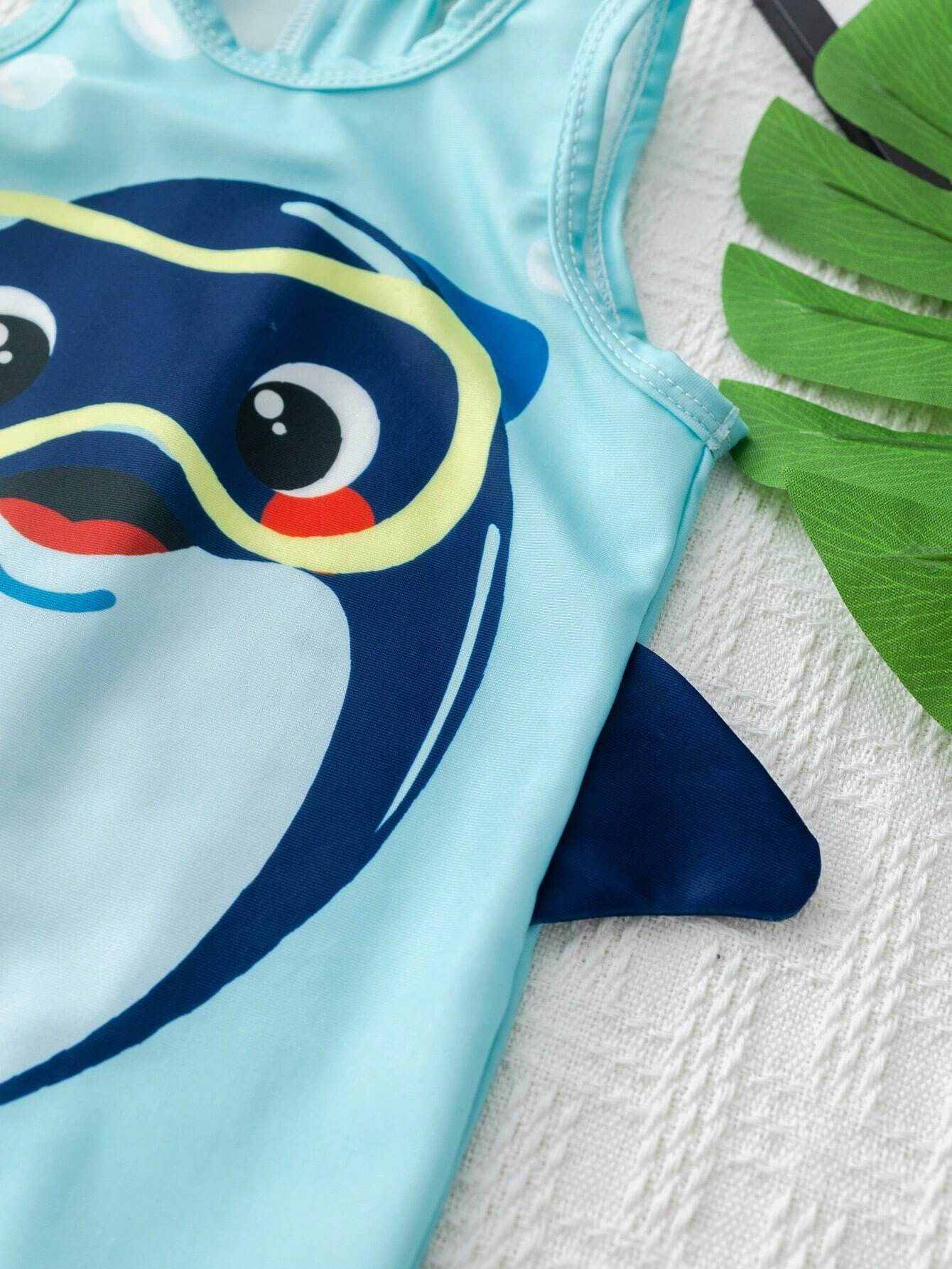 Prenda azul traje de baño delfín para bebe detalle de tela