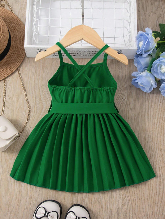 Prenda verde vestido para bebe con tirantes cruzados vista trasera
