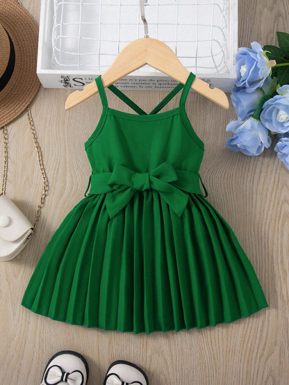 Prenda verde vestido para bebe con tirantes y lazo vista frontal
