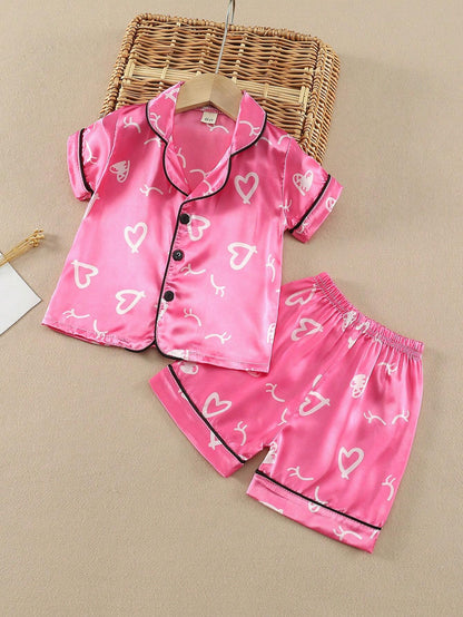 Prenda rosa pijama de satén para bebe vista frontal conjunto dos piezas con estampado de corazones
