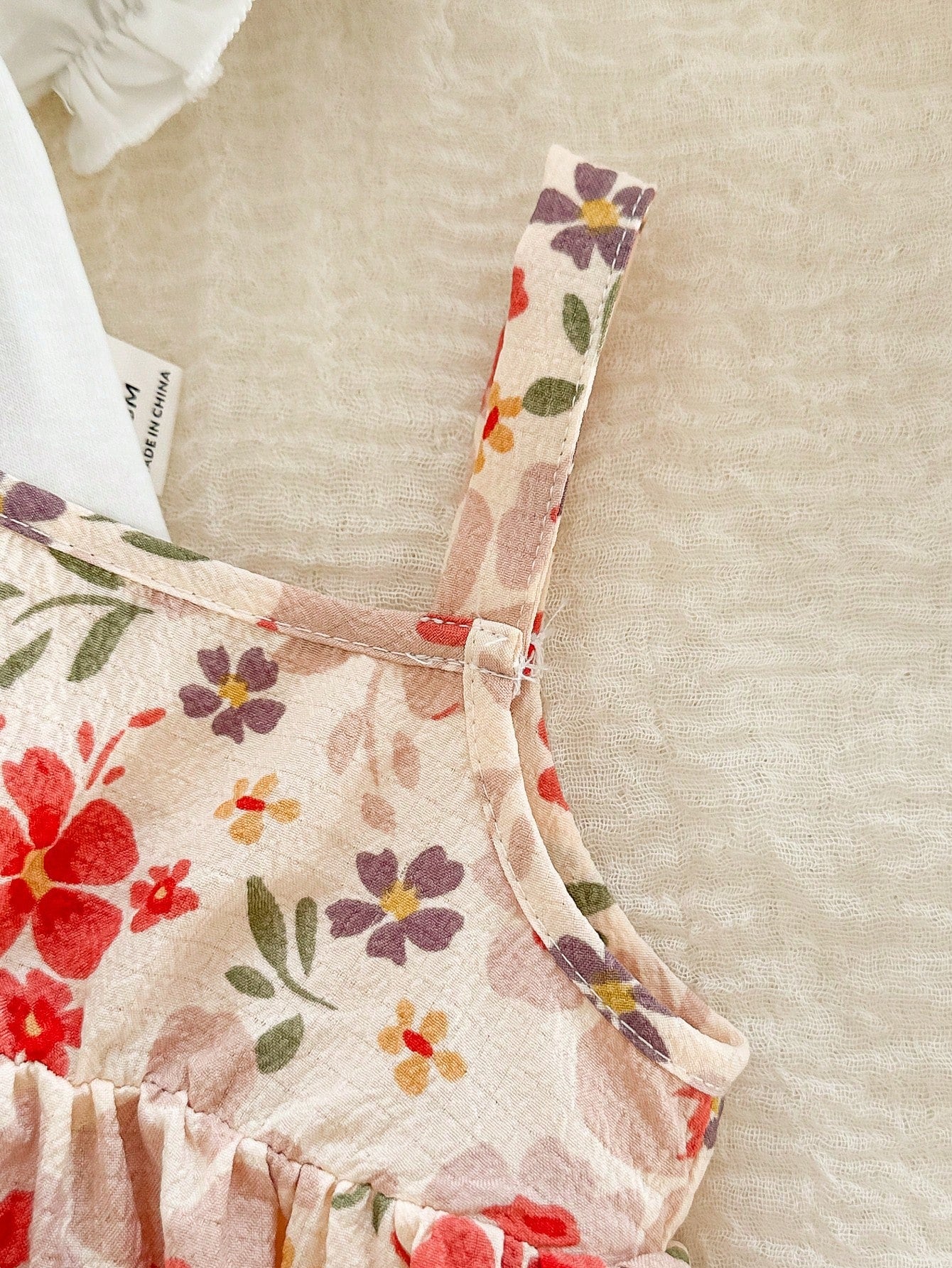 Prenda rosa vestido floral para bebe detalle de tirante