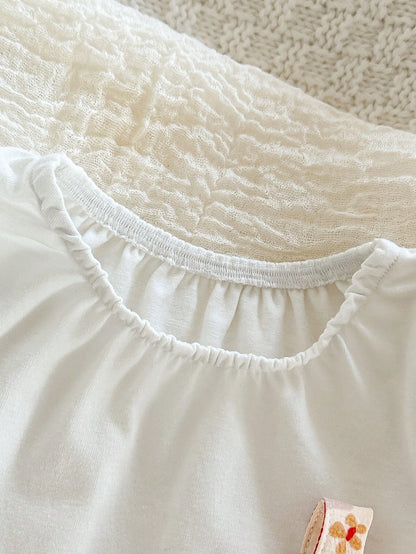 Prenda blanca blusa para bebe con cuello redondo detalle del acabado
