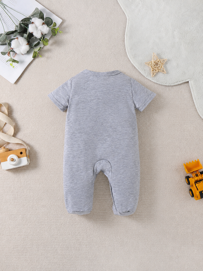 Prenda gris mameluco para bebe con vehículos de construcción detalle frontal