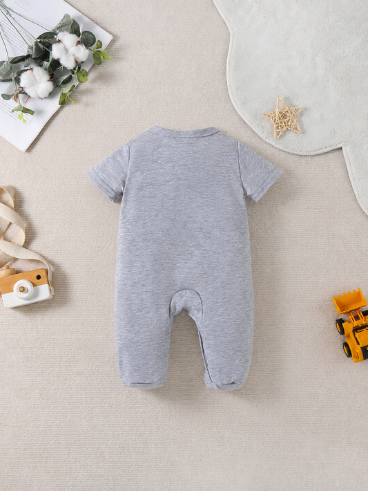 Prenda gris mameluco para bebe con vehículos de construcción detalle frontal