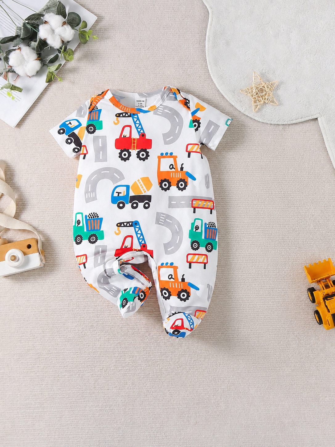 Prenda blanco mameluco para bebe con estampado de construcción vista frontal
