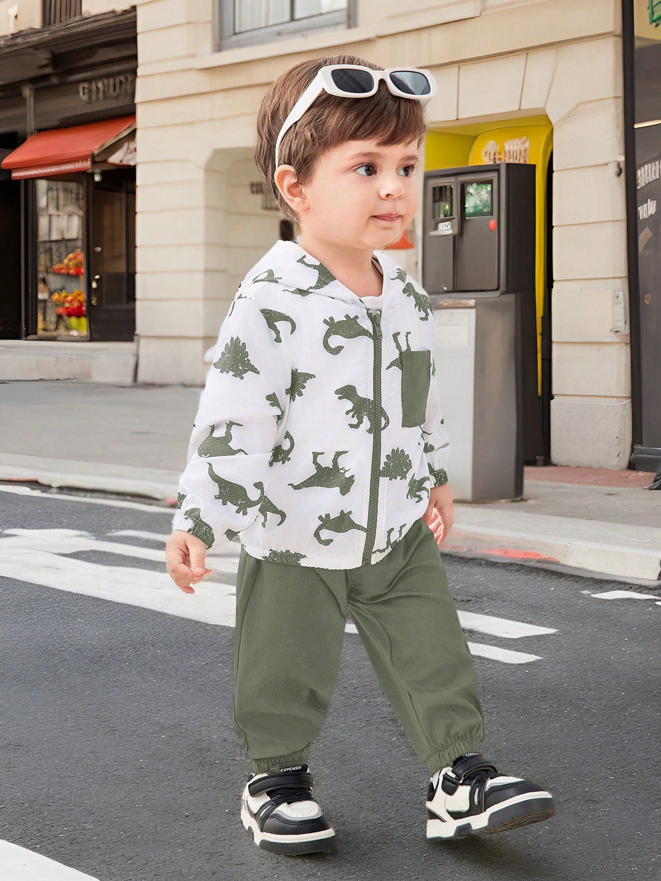 Prenda blanco conjunto para bebe modelando conjunto con dinosaurios y pantalón verde