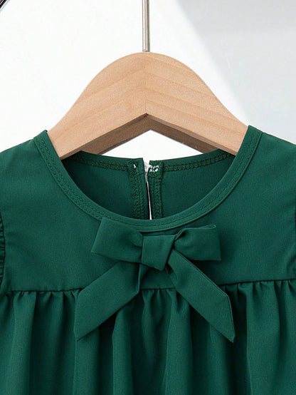 Vestido verde oscuro con moño delantero y mangas con volantes