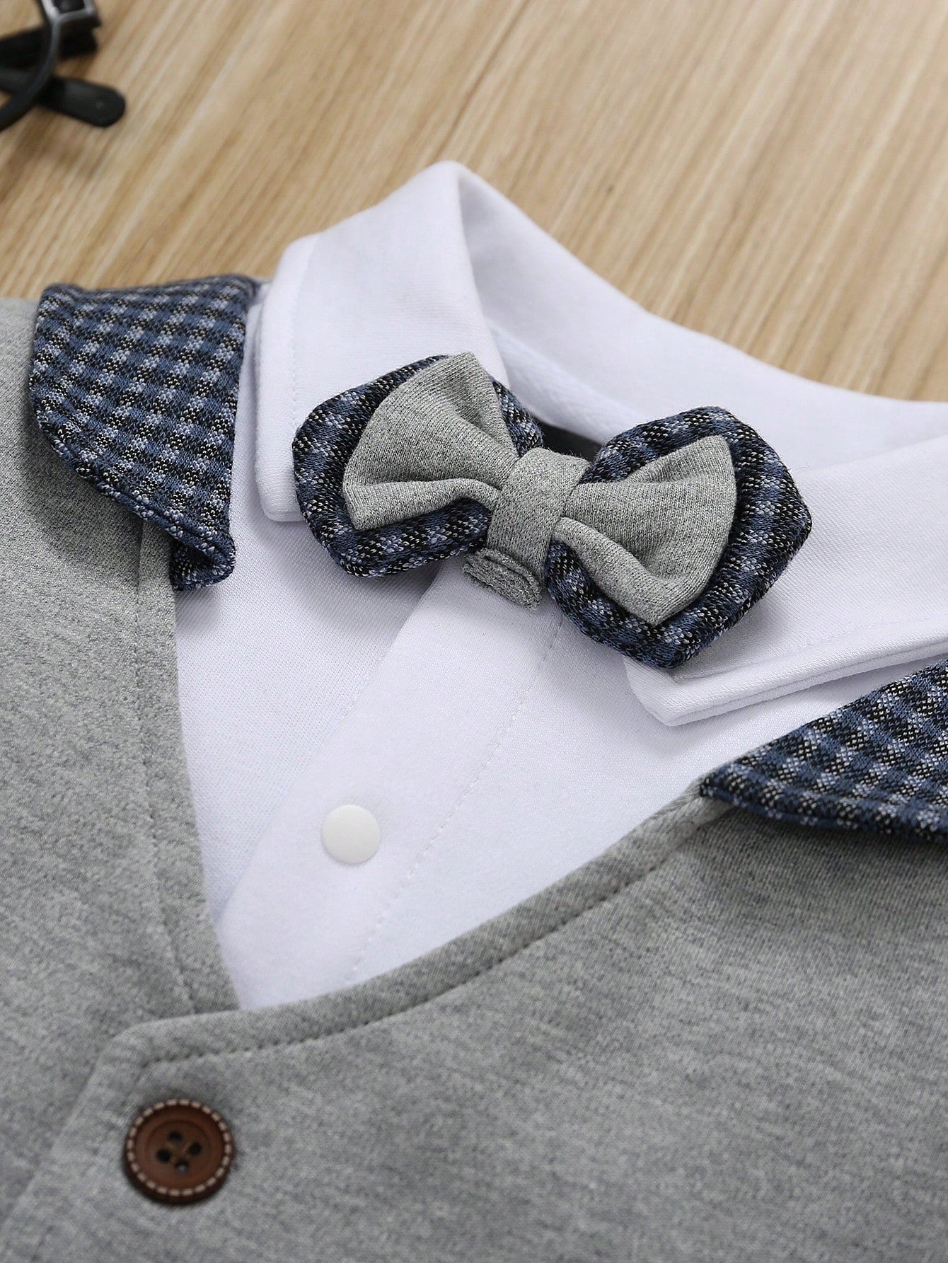 Prenda gris pelele para bebe detalle de pajarita y cuello camisero